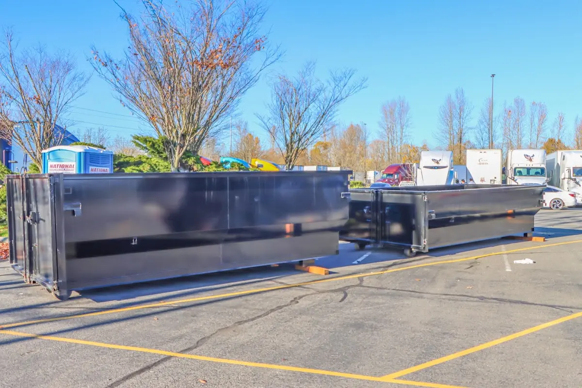 Professional dumpster rental service with roll-off container on residential driveway in Vineyard